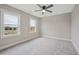 A bedroom featuring neutral carpeting, a ceiling fan, and ample natural light from two windows at O Shortline Rd, Roxboro, NC 27574