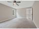 Bright bedroom featuring a ceiling fan, large window, and neutral carpet at O Shortline Rd, Roxboro, NC 27574