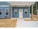 Home's inviting entrance features a covered porch, a white front door, and fresh landscaping at O Shortline Rd, Roxboro, NC 27574