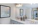 Bright bathroom with double sinks, a large mirror, and decorative elements enhancing its appeal at 100 Cloud Berry Ln, Holly Springs, NC 27540