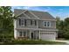 Charming two-story home with gray siding, shutters, attached garage, and a beautifully landscaped front yard at 100 Cloud Berry Ln, Holly Springs, NC 27540