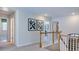 Upstairs hallway with wood railing, artwork, and open doorways leading to other rooms at 100 Cloud Berry Ln, Holly Springs, NC 27540