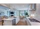Open kitchen with island seating, stainless steel appliances, and a view of the living and dining areas at 100 Cloud Berry Ln, Holly Springs, NC 27540