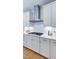 Stylish kitchen with white cabinets, subway tile backsplash, and stainless steel range hood at 100 Cloud Berry Ln, Holly Springs, NC 27540