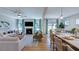 Bright living room with fireplace, TV, and kitchen bar, perfect for entertaining and relaxation at 100 Cloud Berry Ln, Holly Springs, NC 27540
