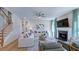 Bright living room with hardwood floors, fireplace, and staircase at 100 Cloud Berry Ln, Holly Springs, NC 27540