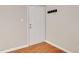 An interior view of a white paneled door with chrome hardware, coat hooks, and wood-look flooring at 108 Ephesus Church Rd # 510, Chapel Hill, NC 27517