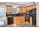 Updated kitchen with black appliances, granite countertops, wood cabinetry, and tile backsplash at 108 Ephesus Church Rd # 510, Chapel Hill, NC 27517
