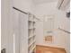 Spacious walk-in closet with white shelving, hanging rods, and wood flooring at 108 Ephesus Church Rd # 510, Chapel Hill, NC 27517