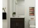 Half bathroom with a dark wood vanity, white countertop, framed mirror, and modern light fixture at 1333 Hazelnut Ridge Ln, Knightdale, NC 27545