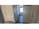 Hallway with a view of the kitchen featuring white cabinets and contrasting wood-look flooring at 1409 Mcdearman Ave, Rocky Mount, NC 27804