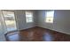 Bright living room with wood-look flooring, two large windows, and neutral paint at 1409 Mcdearman Ave, Rocky Mount, NC 27804