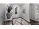 Elegant foyer featuring stylish rug, decorative vase, and view into a bathroom off the entryway at 1702 Red Roses Ave, Durham, NC 27703