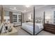 Elegant bedroom with a four-poster bed, tray ceiling, a large window, and soft neutral tones at 1702 Red Roses Ave, Durham, NC 27703