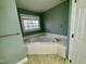 Bathroom with a corner tub and a window providing natural light at 1809 Waddill Way, Henderson, NC 27536