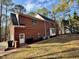 The back of the brick house features a patio and well-kept lawn at 1809 Waddill Way, Henderson, NC 27536