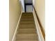 Carpeted staircase with wood handrail leading to upper level of home at 1809 Waddill Way, Henderson, NC 27536