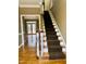 Traditional staircase with carpet runner leading to upper level, hardwood floors and open doorway at 1809 Waddill Way, Henderson, NC 27536