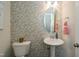 Stylish powder room with patterned wallpaper, a pedestal sink, and a decorative mirror at 2317 Bay Minette Station Sta # 545, Apex, NC 27502