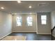 Open concept living room featuring wood-look flooring, three windows, and neutral paint colors at 3002 Honeymyrtle Ln, Durham, NC 27703