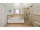 Bathroom with a soaking tub and walk-in shower, all in a neutral tile at 3104 Sandy Knoll Ln, Knightdale, NC 27545