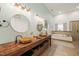 Bathroom with double sinks, wooden furniture and big round mirror at 3104 Sandy Knoll Ln, Knightdale, NC 27545