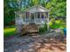 Charming exterior view of a quaint, raised cottage with a screened porch and natural surroundings at 3104 Sandy Knoll Ln, Knightdale, NC 27545
