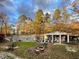 Ranch style home featuring a covered porch, fire pit, wooded setting, and manicured lawn at 3104 Sandy Knoll Ln, Knightdale, NC 27545