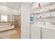 Modern laundry room and bath combo with washer, dryer, and storage shelves at 3104 Sandy Knoll Ln, Knightdale, NC 27545