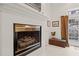 Cozy living room featuring a fireplace with white mantle and view to the outside with golden curtains at 3104 Sandy Knoll Ln, Knightdale, NC 27545