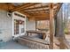 Covered outdoor dining area with wooden table and stone bench seating, perfect for entertaining at 3104 Sandy Knoll Ln, Knightdale, NC 27545