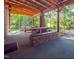 Outdoor dining area with wooden tables, stone benches, and a covered structure perfect for entertaining at 3104 Sandy Knoll Ln, Knightdale, NC 27545