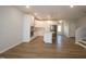 Open-concept living room with hardwood floors flowing into the modern kitchen and stainless appliances at 3195 Mission Olive Pl # 352, New Hill, NC 27562