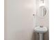 Powder room featuring a pedestal sink, round mirror, and neutral paint, creating a simple and clean space at 3716 Yorktown Pl, Raleigh, NC 27609