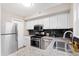 Modern kitchen featuring white cabinets, stainless steel appliances, granite countertops, and dark backsplash at 3716 Yorktown Pl, Raleigh, NC 27609
