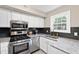 Modern kitchen with stainless steel appliances, granite countertops, and sleek cabinetry, perfect for cooking at 3716 Yorktown Pl, Raleigh, NC 27609