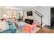 Open-concept living room with hardwood floors, modern furniture, and access to the staircase and dining area at 3716 Yorktown Pl, Raleigh, NC 27609