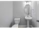 Well-lit half bathroom with modern pedestal sink, toilet, and decorative mirror at 376 Buckhorn Branch Park # 38, Clayton, NC 27520