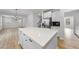Open kitchen with island transitions to living area, featuring white cabinets and stainless steel appliances at 376 Buckhorn Branch Park # 38, Clayton, NC 27520