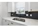 Close up of sink area with quartz countertop, black backsplash, and white cabinets at 376 Buckhorn Branch Park # 38, Clayton, NC 27520