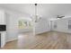 Open concept living room with modern chandelier, large windows, and wood floors at 376 Buckhorn Branch Park # 38, Clayton, NC 27520