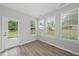 Bright sunroom featuring natural light, wood floors, and glass door to backyard at 376 Buckhorn Branch Park # 38, Clayton, NC 27520