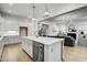 Open-concept kitchen with stainless steel appliances, white cabinetry, and a view into the living room at 3812 Cobbler View Way, Fuquay Varina, NC 27526