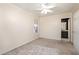 This bedroom features neutral walls, carpet, a ceiling fan, and a large window for lots of natural light at 4102 Panther Creek Pkwy, Durham, NC 27704