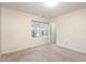 A carpeted bedroom with a large window offering natural light and a peaceful view of the outdoors at 4102 Panther Creek Pkwy, Durham, NC 27704