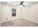 Comfortable carpeted bedroom with ceiling fan, window providing natural light, and neutral walls at 4102 Panther Creek Pkwy, Durham, NC 27704