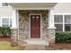 Inviting covered front porch with stone pillars and a dark wooden front door at 4102 Panther Creek Pkwy, Durham, NC 27704