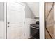 A well-organized laundry room with modern washer/dryer, white shelving, and a convenient side entry door at 4102 Panther Creek Pkwy, Durham, NC 27704