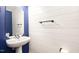 A stylish powder room with a pedestal sink, shiplap wall, and unique mirror creating a modern, inviting space at 4102 Panther Creek Pkwy, Durham, NC 27704