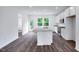 Bright kitchen with white cabinets, stainless appliances, granite countertops and dark laminate flooring at 427 Rowe Way, Knightdale, NC 27545
